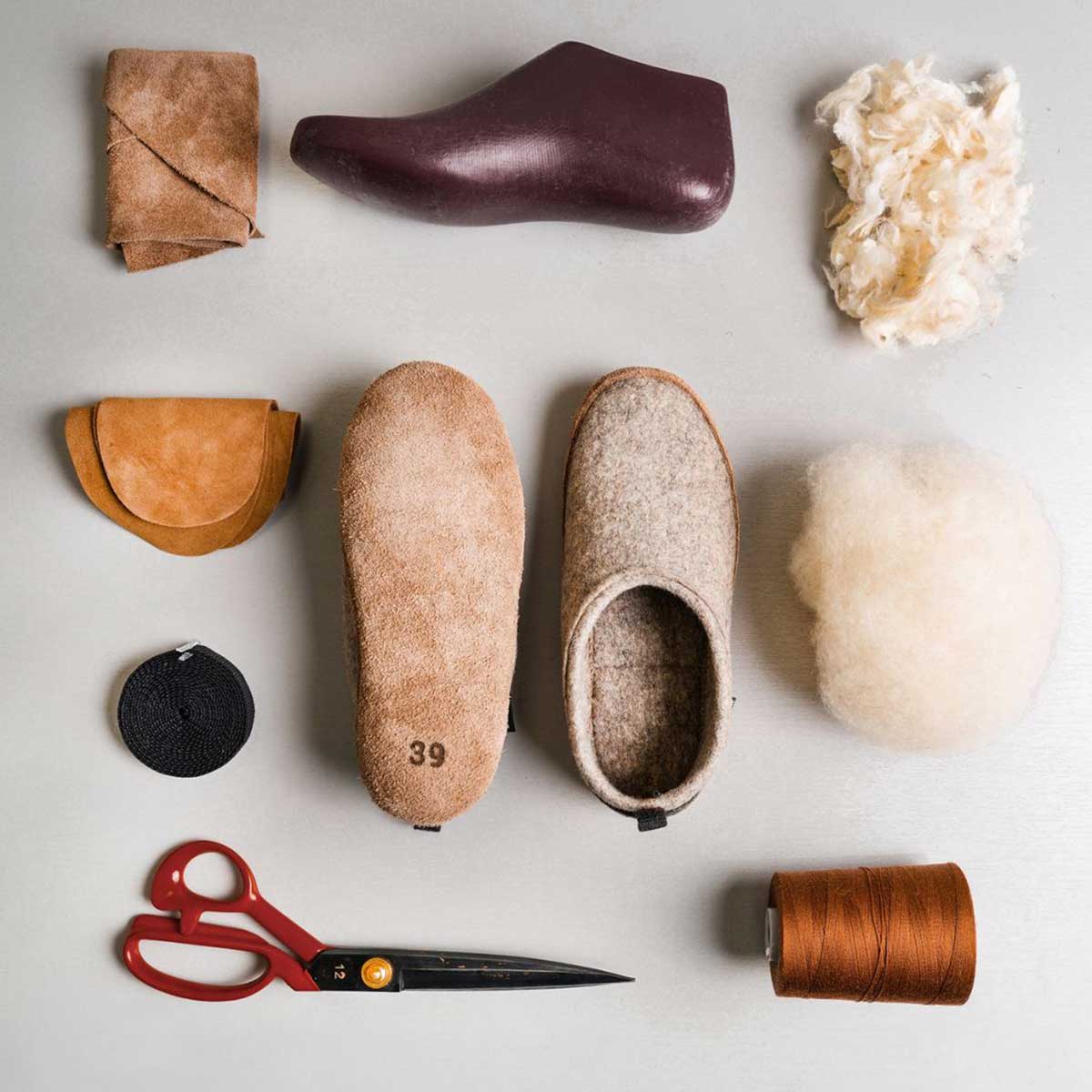Zur Herstellung benötigt man nicht viel. Auf dem Bild zu sehen: Hausschuhe, Garn, Wolle, eine Schere, einen Schuhleisten und Leder.